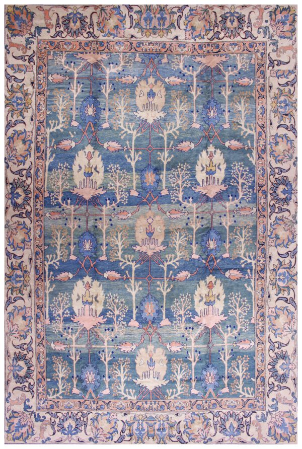 An antique/collectable rug with a blue background, pink border, and intricate design